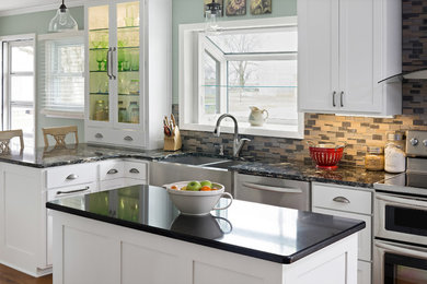 Inspiration for a mid-sized timeless l-shaped medium tone wood floor eat-in kitchen remodel in Kansas City with a farmhouse sink, shaker cabinets, white cabinets, quartz countertops, gray backsplash, stainless steel appliances and an island