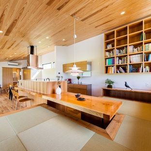Exemple d'une salle à manger ouverte sur le salon tendance avec un mur blanc, un sol de tatami et un sol vert.