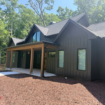 Moody Palette: Deep, dark-painted board and batten siding paired with upper gabl