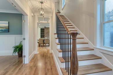 Example of a large farmhouse light wood floor and beige floor entryway design in Boston with gray walls