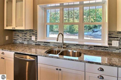 Eat-in kitchen - large contemporary u-shaped dark wood floor eat-in kitchen idea in Detroit with an undermount sink, shaker cabinets, white cabinets, granite countertops, multicolored backsplash, glass tile backsplash, stainless steel appliances and an island