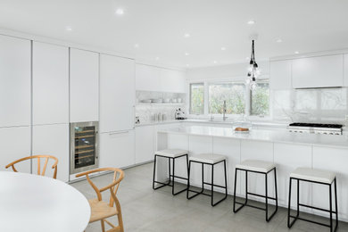 Inspiration for a large contemporary gray floor kitchen remodel in Chicago with an integrated sink, recessed-panel cabinets, white cabinets, quartzite countertops, white backsplash, marble backsplash, stainless steel appliances, an island and white countertops