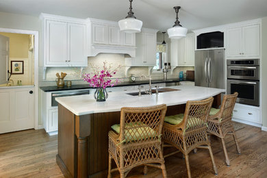 Inspiration for a large timeless l-shaped dark wood floor eat-in kitchen remodel in Denver with an undermount sink, recessed-panel cabinets, white cabinets, marble countertops, white backsplash, brick backsplash, stainless steel appliances and an island