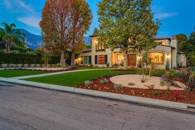 Large mediterranean beige two-story stucco house exterior idea in Los Angeles with a hip roof and a tile roof