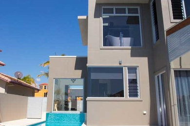 Inspiration for a large contemporary three-storey exterior in Brisbane with a flat roof.