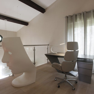 Kleines Modernes Arbeitszimmer mit Arbeitsplatz, beiger Wandfarbe, gebeiztem Holzboden, freistehendem Schreibtisch, beigem Boden und freigelegten Dachbalken in Nizza