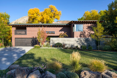 Photo of a mid-sized contemporary split-level brick brown house exterior in Salt Lake City with a butterfly roof and a shingle roof.