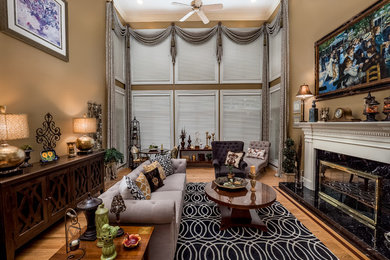 This is an example of a large traditional formal enclosed living room in St Louis with brown walls, medium hardwood floors, a standard fireplace, a tile fireplace surround, no tv and brown floor.
