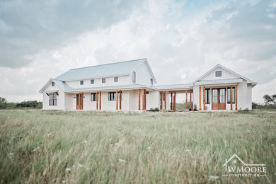 Inspiration for a country white two-story wood house exterior remodel in Other with a metal roof