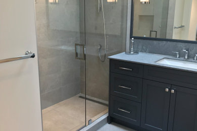 Example of a mid-sized 1960s 3/4 gray tile and porcelain tile porcelain tile, gray floor and single-sink bathroom design in Vancouver with a freestanding vanity, flat-panel cabinets, black cabinets, an undermount sink, quartzite countertops, gray countertops and a niche