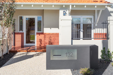 This is an example of a mid-sized traditional front door in Perth with beige walls, concrete floors, a single front door, a glass front door and multi-coloured floor.