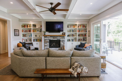 Mid-sized elegant open concept brown floor living room photo in Detroit with gray walls, a standard fireplace, a stone fireplace and a wall-mounted tv