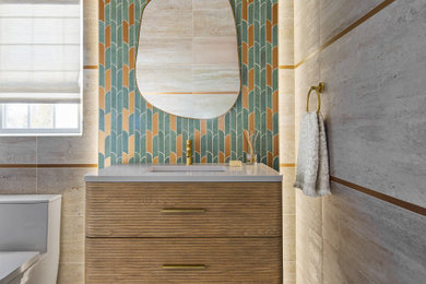 Small trendy green tile and porcelain tile porcelain tile and beige floor powder room photo in Newark with furniture-like cabinets, light wood cabinets, a one-piece toilet, beige walls, quartz countertops, white countertops, a freestanding vanity and an undermount sink