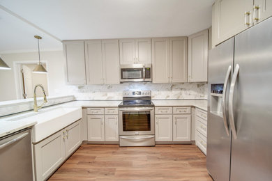 Inspiration for a country u-shaped kitchen remodel in Charlotte with a farmhouse sink, shaker cabinets, granite countertops, ceramic backsplash and stainless steel appliances