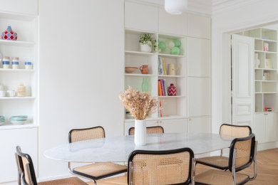 Aménagement d'une grande salle à manger ouverte sur la cuisine scandinave avec un mur blanc, parquet clair et verrière.