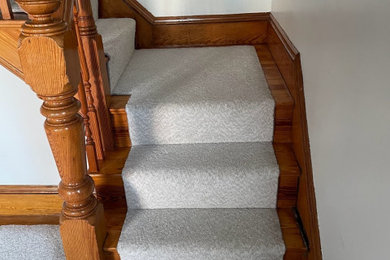 Example of a mid-sized classic carpeted l-shaped wood railing staircase design in Boston with carpeted risers