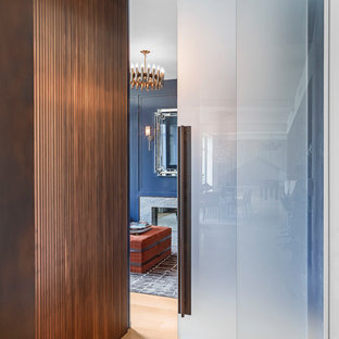 Modern study in New York with blue walls, a two-sided fireplace, a stone fireplace surround and a built-in desk.