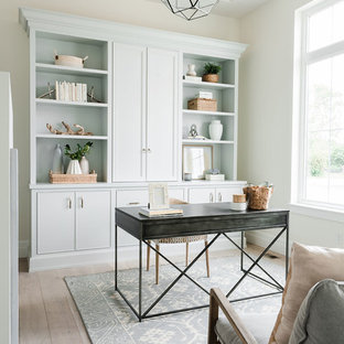 Inredning av ett maritimt hemmabibliotek, med vita väggar, ljust trägolv och ett fristående skrivbord