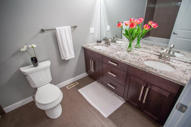 Example of a mid-sized classic master vinyl floor tub/shower combo design in Other with shaker cabinets, medium tone wood cabinets, a two-piece toilet, gray walls, an undermount sink and quartz countertops