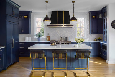 Inspiration for a large transitional u-shaped medium tone wood floor and brown floor kitchen remodel in Denver with an undermount sink, shaker cabinets, blue cabinets, white backsplash, stainless steel appliances, an island and white countertops