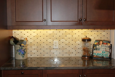 Kitchen - traditional kitchen idea in Toronto with recessed-panel cabinets, medium tone wood cabinets, marble countertops, beige backsplash and stone tile backsplash