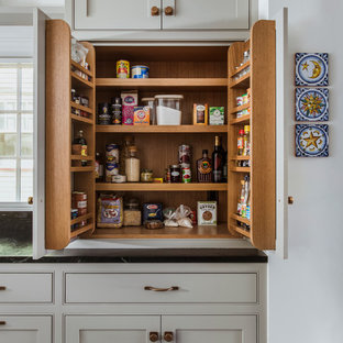 Foto på ett stort vintage svart kök, med en undermonterad diskho, luckor med profilerade fronter, grå skåp, blått stänkskydd, integrerade vitvaror, en köksö och grått golv