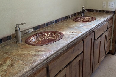 Multicolored tile bathroom photo with medium tone wood cabinets and tile countertops