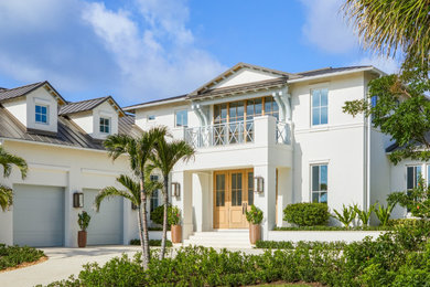 Transitional white two-story concrete house exterior idea in Miami with a brown roof