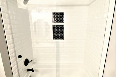 他の地域にあるトラディショナルスタイルのおしゃれな浴室 (アルコーブ型浴槽、シャワー付き浴槽	、引戸のシャワー) の写真