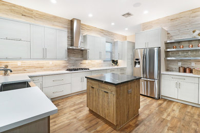 Inspiration for a mid-sized contemporary u-shaped vinyl floor and brown floor open concept kitchen remodel in Phoenix with a single-bowl sink, flat-panel cabinets, white cabinets, quartz countertops, multicolored backsplash, ceramic backsplash, stainless steel appliances, an island and white countertops
