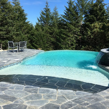 Vanishing Edge Concrete pool with spa and water feature