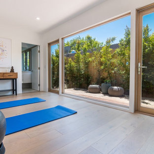 ロサンゼルスの中サイズのミッドセンチュリースタイルのおしゃれなヨガスタジオ (白い壁、無垢フローリング、茶色い床) の写真