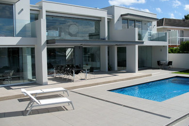 This is an example of a mid-sized modern two-storey stucco grey house exterior in Sydney with a flat roof.