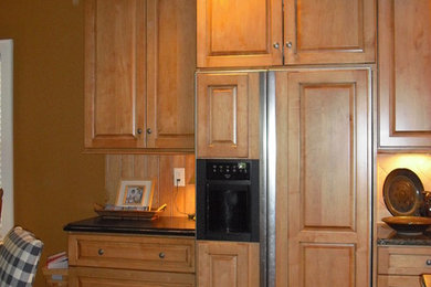 Photo of a traditional galley eat-in kitchen in Other with raised-panel cabinets, light wood cabinets, granite benchtops, ceramic splashback and panelled appliances.