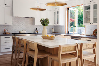 Exempel på ett mellanstort modernt grå grått kök, med en undermonterad diskho, skåp i shakerstil, vita skåp, bänkskiva i kvartsit, vitt stänkskydd, stänkskydd i keramik, rostfria vitvaror, laminatgolv och en köksö