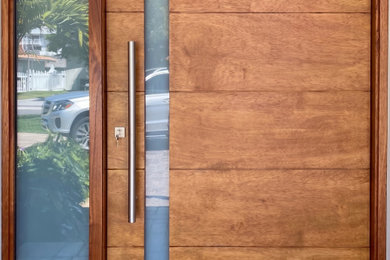 Example of a large minimalist entryway design in Miami with a light wood front door