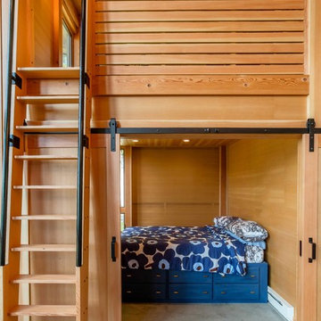 Queen size bedroom with sliding barn doors and sleeping loft above.
