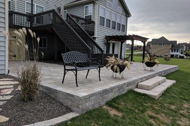 Mid-sized elegant backyard concrete paver patio photo in Chicago with a pergola