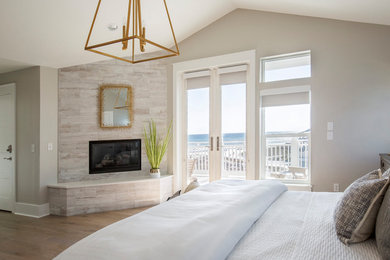 Beach style bedroom in Miami with beige walls, light hardwood floors and brown floor.