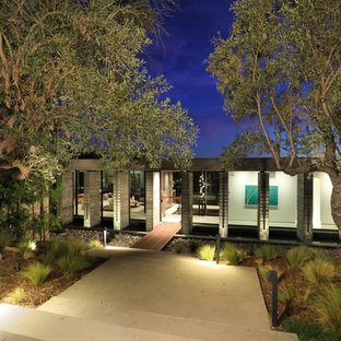 オレンジカウンティのコンテンポラリースタイルのおしゃれな家の外観 (ガラスサイディング、陸屋根、戸建) の写真