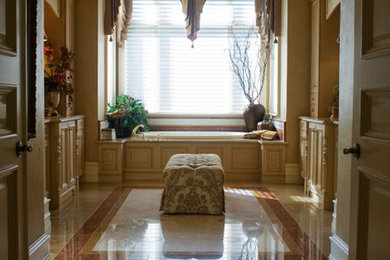 Bathroom - large traditional beige tile and stone tile marble floor and beige floor bathroom idea in Atlanta with raised-panel cabinets, beige cabinets, a one-piece toilet, beige walls, an undermount sink, marble countertops and a hinged shower door