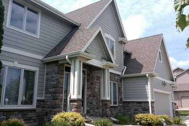 Large trendy gray two-story mixed siding exterior home photo in Other