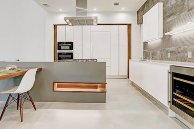 1950s kitchen photo in Houston with flat-panel cabinets, white cabinets, stainless steel countertops, porcelain backsplash, stainless steel appliances and white countertops