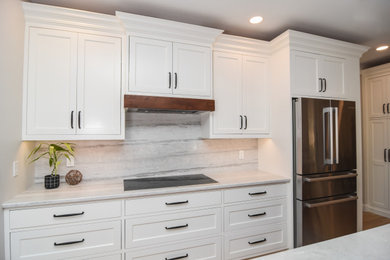 Eat-in kitchen - mid-sized transitional single-wall eat-in kitchen idea in Boston with an undermount sink, shaker cabinets, white cabinets, quartzite countertops, gray backsplash, quartz backsplash, stainless steel appliances, an island and white countertops