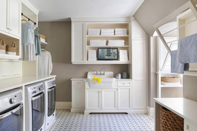 Huge u-shaped ceramic tile and multicolored floor dedicated laundry room photo in Dallas with a farmhouse sink, shaker cabinets, white cabinets, wood countertops, beige walls, a side-by-side washer/dryer and white countertops