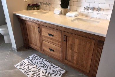 Bathroom - bathroom idea in St Louis with recessed-panel cabinets, medium tone wood cabinets, an undermount sink, quartz countertops and white countertops