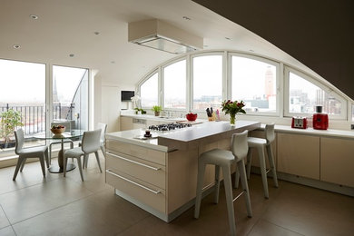 Photo of a mid-sized contemporary u-shaped eat-in kitchen in London with an integrated sink, flat-panel cabinets, beige cabinets, solid surface benchtops, white splashback, stainless steel appliances, ceramic floors and with island.