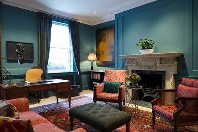 ロンドンにある中くらいなトラディショナルスタイルのおしゃれなホームオフィス・書斎 (青い壁、カーペット敷き、標準型暖炉、石材の暖炉まわり、自立型机、白い床) の写真