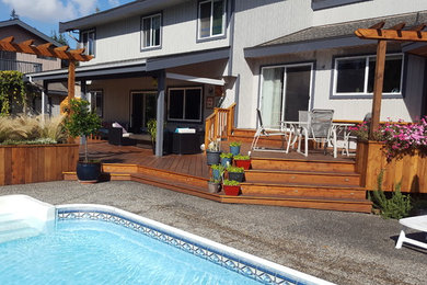 Mid-sized elegant backyard deck photo in Vancouver with a roof extension