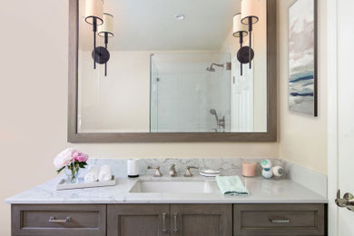 Mid-sized trendy master single-sink drop-in bathtub photo in Los Angeles with shaker cabinets, brown cabinets, an undermount sink, marble countertops and a built-in vanity